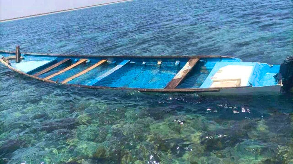 HANDOUT - A capsized boat lies on a beach. According to the United Nations migration agency, several migrants have died on the journey in a boat and others have been rescued from a shipwreck off Djibouti on a popular route to Yemen. Photo: IOM/International Organization for Migration/AP/dpa