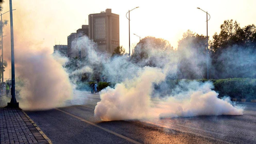 Police officers in the Pakistani capital Islamabad fire tear gas at demonstrators. Photo: W.K. Yousafzai/AP/dpa