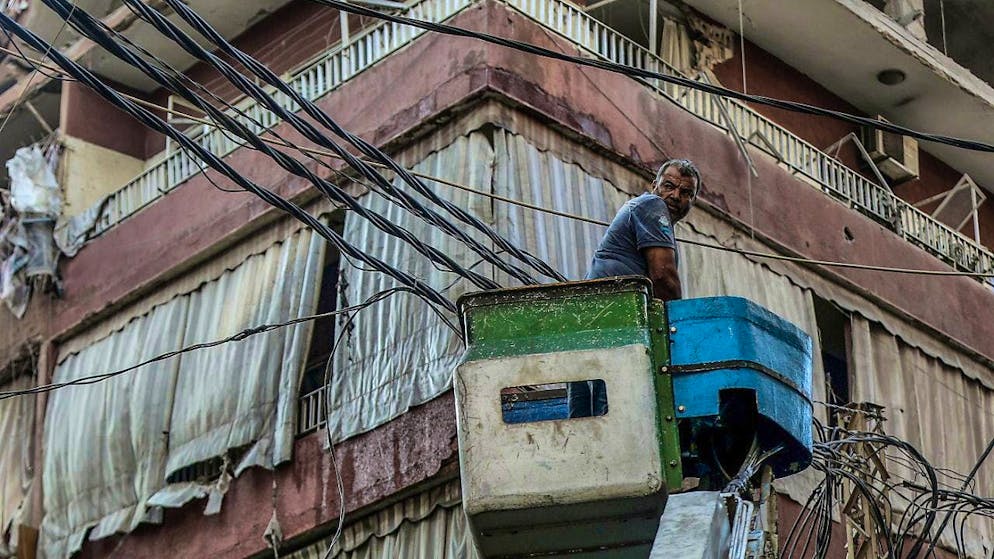 ARCHIVE - An electrician removes cables from a damaged building hit by an Israeli airstrike in a southern suburb of Beirut. Photo: Marwan Naamani/dpa