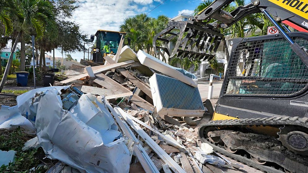 Rettungsmannschaften bei der Bergung von durch den Hurrikan «Helene» beschädigtem Hausrat vor dem möglichen Auftreffen des Hurrikans «Milton». Foto: Chris O'Meara/AP/dpa