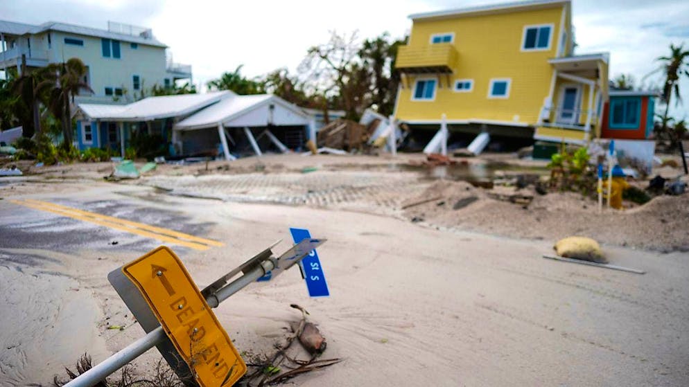 A house has fallen off its stilts after the passage of Hurricane Milton and stands next to an empty lot where a house was swept away by Hurricane Helene on Anna Maria Island. Photo: Rebecca Blackwell/AP/dpa