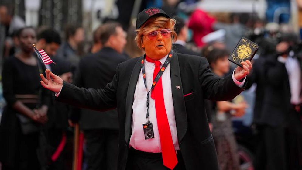 Eine als Donald Trump verkleidete Person gestikuliert bei der Ankunft zur Premiere des Films «The Apprentice» bei den 77. Internationalen Filmfestspielen von Cannes für Fotografen.