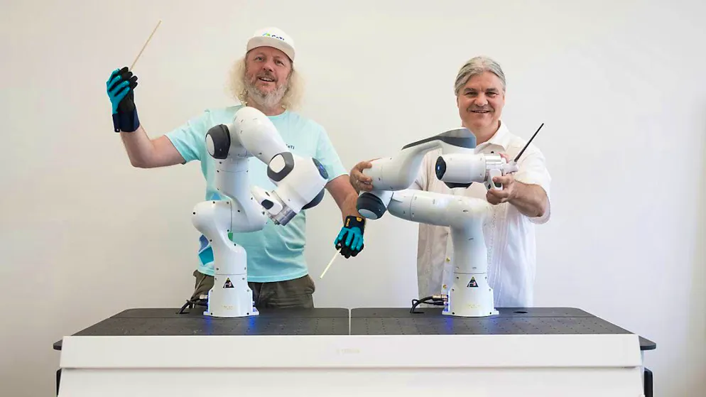 Frank Fitzek, spokesman for the CeTI (Centre for Tactile Internet with Human-in-the-Loop) Cluster of Excellence at Dresden University of Technology, wears data gloves and presents the two collaborative robots together with Markus Rindt, director of the Dresden Symphony Orchestra. (archive picture)