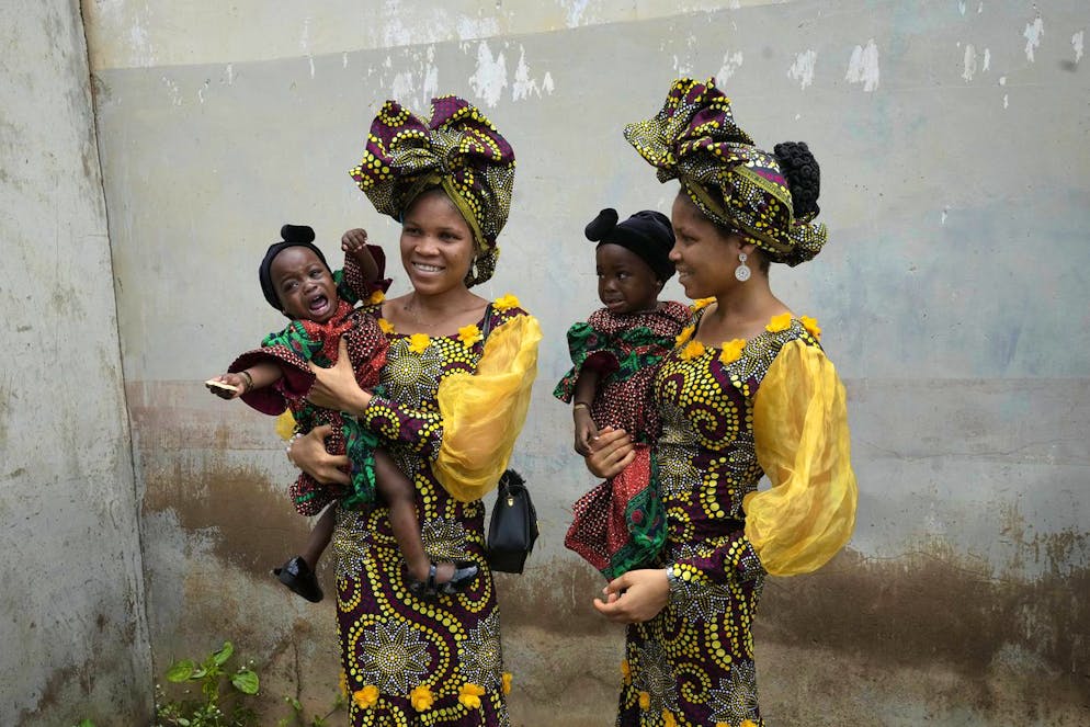 Nigeria jumeaux. Les jumelles Oladapo Taiwo, à gauche, et Oladapo Kehinde, 21 ans, posent pour des photos en tenant les jumeaux d'un parent lors du festival. (AP Photo/Sunday Alamba)