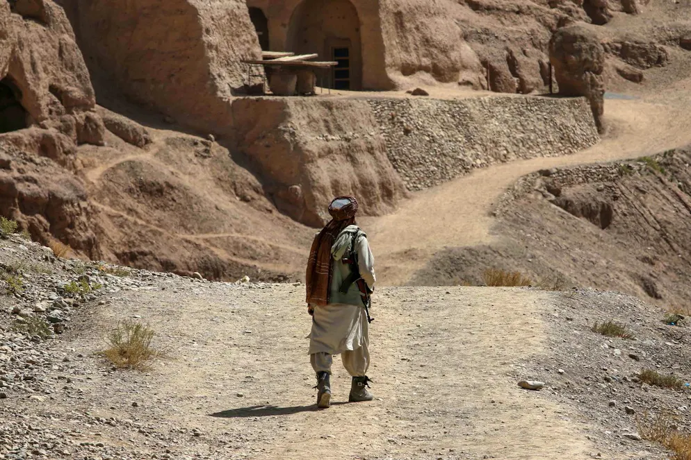 Un membre des forces de sécurité talibanes monte la garde près du site où se trouvait l'une des deux statues colossales de Bouddha sculptées dans les falaises de grès et détruites par les talibans en mars 2001, à Bamiyan, en Afghanistan, le 30 août 2023.