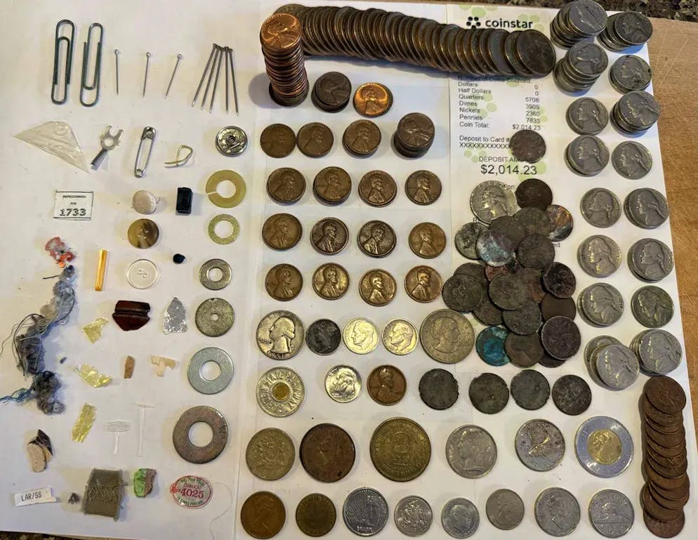 Auf diesem Bild sind alle historischen Münzen und einige Alltagsgegenstände zu sehen, die in dem Glas gefunden wurden. 