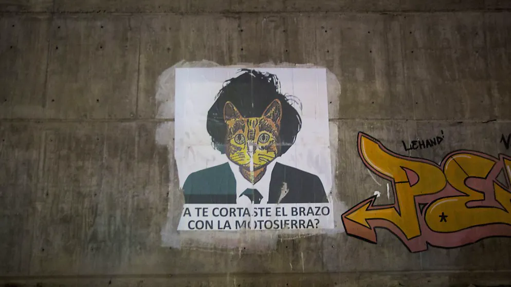 Une affiche critiquant le président argentin Javier Milei est accrochée le long d'un trottoir de La Rioja, en Argentine. Elle pose la question en espagnol: "Te couperais-tu le bras avec la tronçonneuse ?", en référence aux mesures d'austérité.