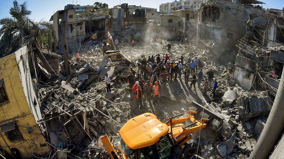 Mitarbeiter des libanesischen Zivilschutzes versammeln sich an dem Ort, der von israelischen Luftangriffen in einem bewohnten Gebiet und nicht weit vom wichtigsten öffentlichen Krankenhaus betroffen war. Foto: Stringer/dpa