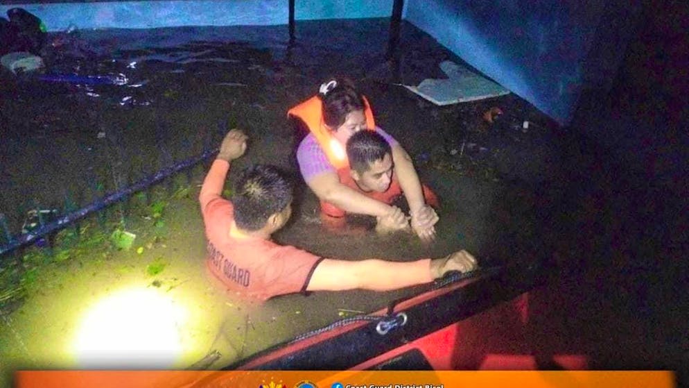 dpatopbilder - HANDOUT - Rescue workers bring a resident to safety. Photo: Philippine Coast Guard/AP/dpa - ATTENTION: For editorial use only in connection with current reporting and only with full attribution of the above credit