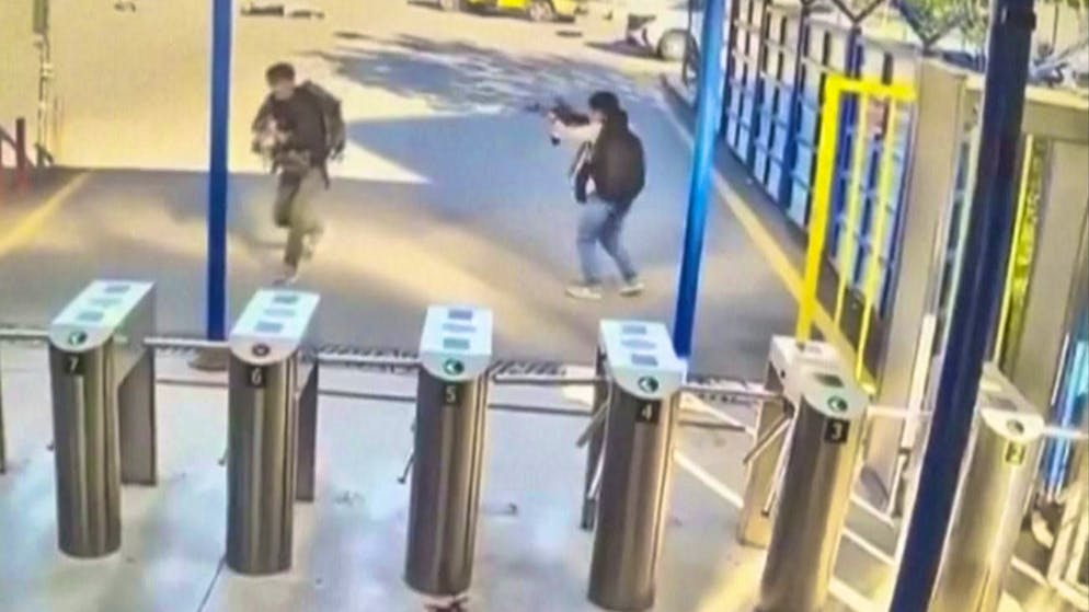 An image from a surveillance camera shows two people with rifles and backpacks attacking a Turkish defense company on Wednesday.