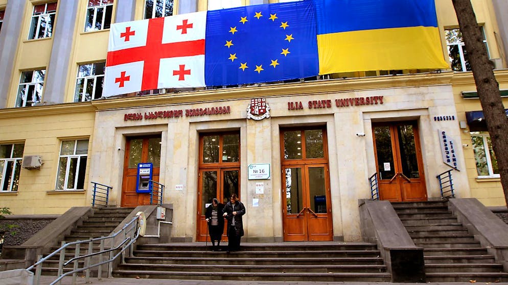 Die Flaggen von Georgien (l-r), der EU und der Ukraine hängen während der Parlamentswahlen in Georgien an der Außenwand eines Wahllokals in Tiflis. Foto: Shakh Aivazov/AP/dpa