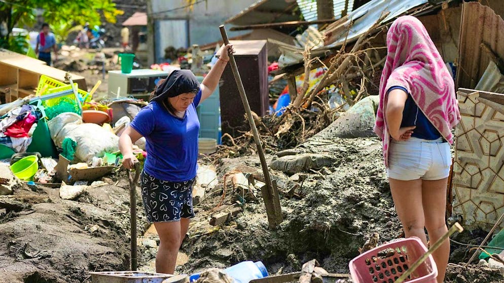People in the Philippine province of Batangas try to salvage belongings from their homes damaged by tropical storm Trami. Photo: Aaron Favila/AP/dpa