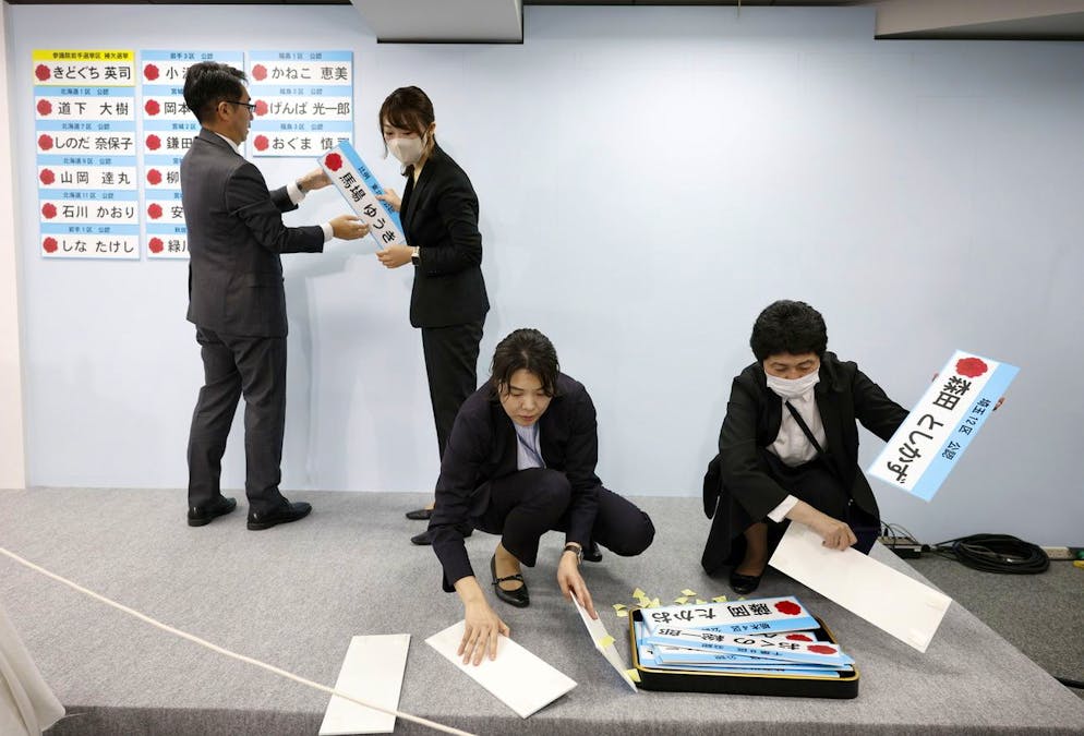 Des membres du personnel du Parti démocrate constitutionnel du Japon (CDP), principal parti d'opposition, fixent les plaques des candidats élus au siège du parti, à Tokyo, Japon, le 27 octobre 2024. Selon les sondages de sortie des urnes de Jiji Press, il devrait être difficile pour le Parti libéral démocrate au pouvoir d'obtenir une majorité à la chambre basse du parlement.