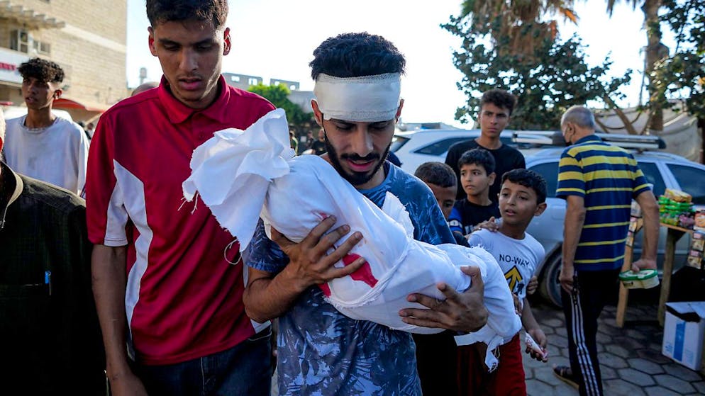 ARCHIV - Ein Angehöriger hält die Leiche eines Kindes, das bei der israelischen Bombardierung des Gazastreifens getötet wurde, in einer Leichenhalle des Krankenhauses in Deir al-Balah. Foto: Abdel Kareem Hana/AP/dpa