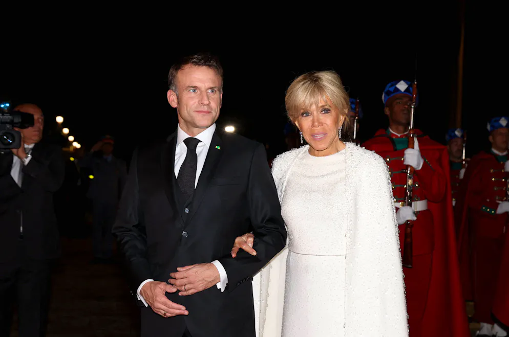 La robe-cape de Brigitte Macron. Aurait-elle choisi le blanc – couleur de la paix – comme déclaration politique? Cela reste un secret.