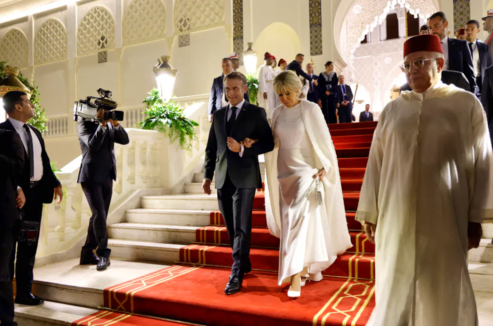 La robe-cape de Brigitte Macron. Si sa robe était parfaitement coupée à ras le sol, c'est telle une princesse qu’elle a toutefois dû la soulever en descendant les marches du palais.