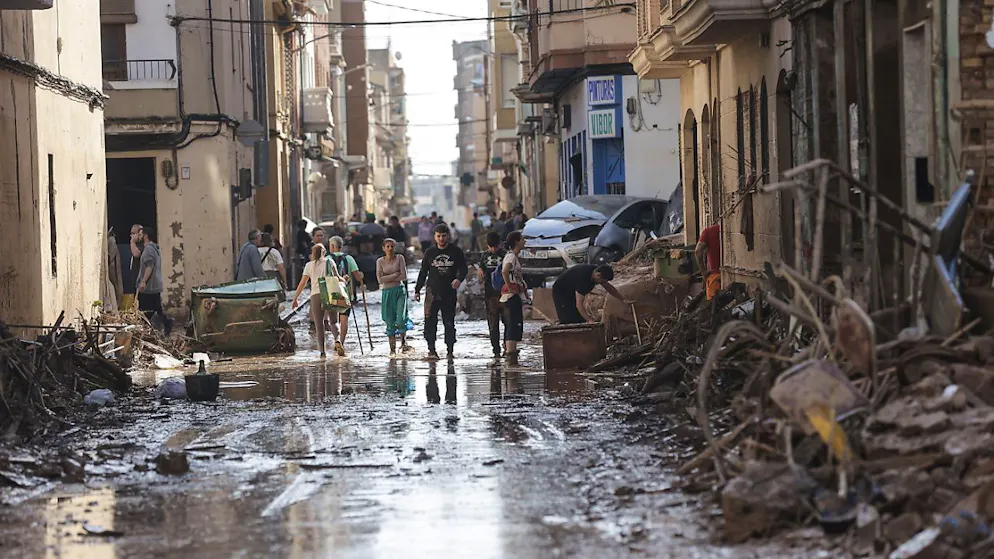 Anwohner gehen durch eine durch Überschwemmungen beschädigte Strasse in der Gemeinde Catarroja, Valencia
