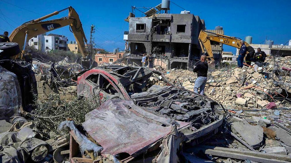 Rescue workers use excavators to remove the rubble of a destroyed building that was hit by an Israeli air strike. Photo: Bilal Hussein/AP/dpa