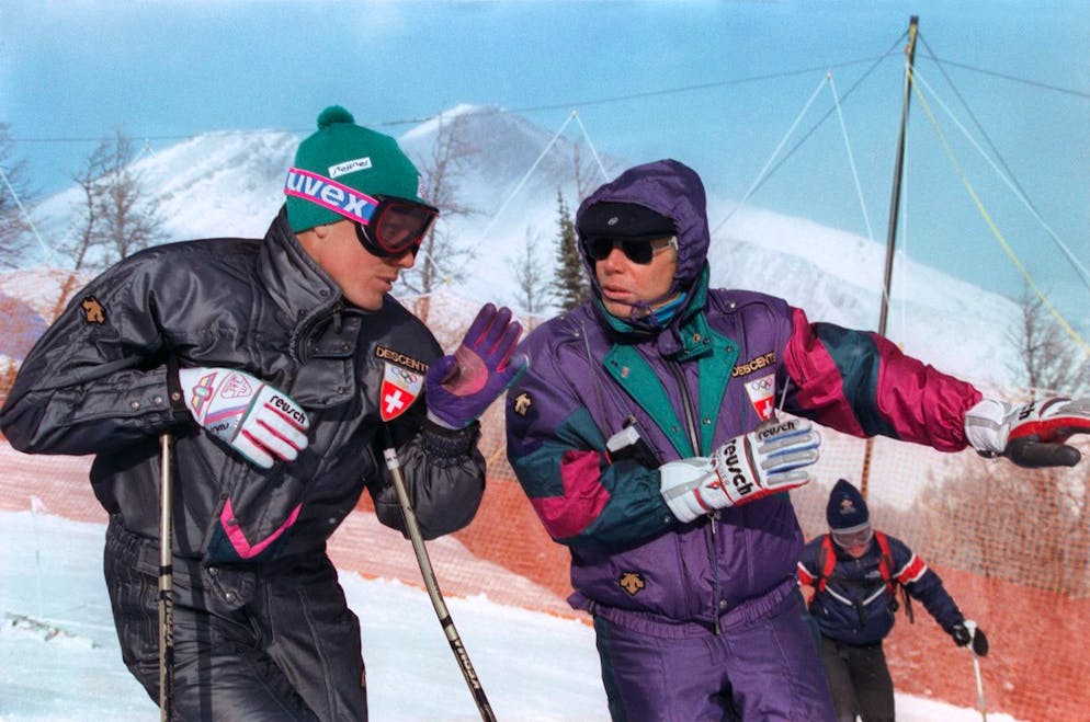 Pirmin Zurbriggen - der grösste Skistar der 80er-Jahre. Der eiserne Karl und sein grösster Star: Karl Frehsner, rechts, Trainer der Schweizer Ski-Nationalmannschaft, erteilt Pirmin Zurbriggen, links, vor dem Abfahrtsrennen der olympischen Winterspiele 1988 in Calgary Ratschläge. Zurbriggen gewinnt anschliessend die Goldmedaille. (KEYSTONE/Thomas Studhalter)