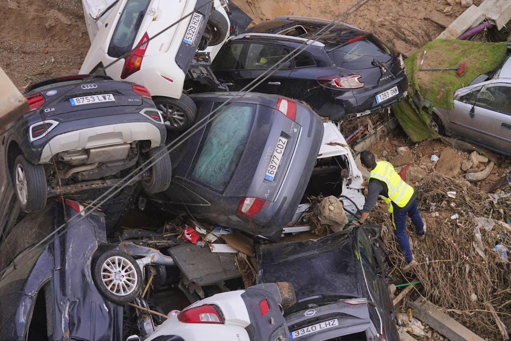 A civil guard searches for survivors in cars piled up on the outskirts of Valencia, Spain, Friday, Nov. 1, 2024 after flooding. (AP Photo/Alberto Saiz)