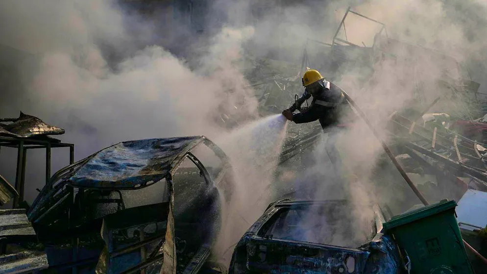 A civil defense worker extinguishes a fire as smoke rises from the site of an Israeli airstrike in the Dahieh neighborhood, Hezbollah's stronghold. Photo: Hassan Ammar/AP/dpa