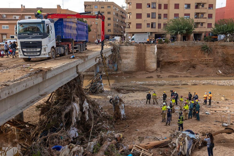 Le inondazioni in Spagna. Un macchinario pesante rimuove un'auto dopo l'alluvione improvvisa a Paiporta, provincia di Valencia, che ha causato almeno 200 morti. 