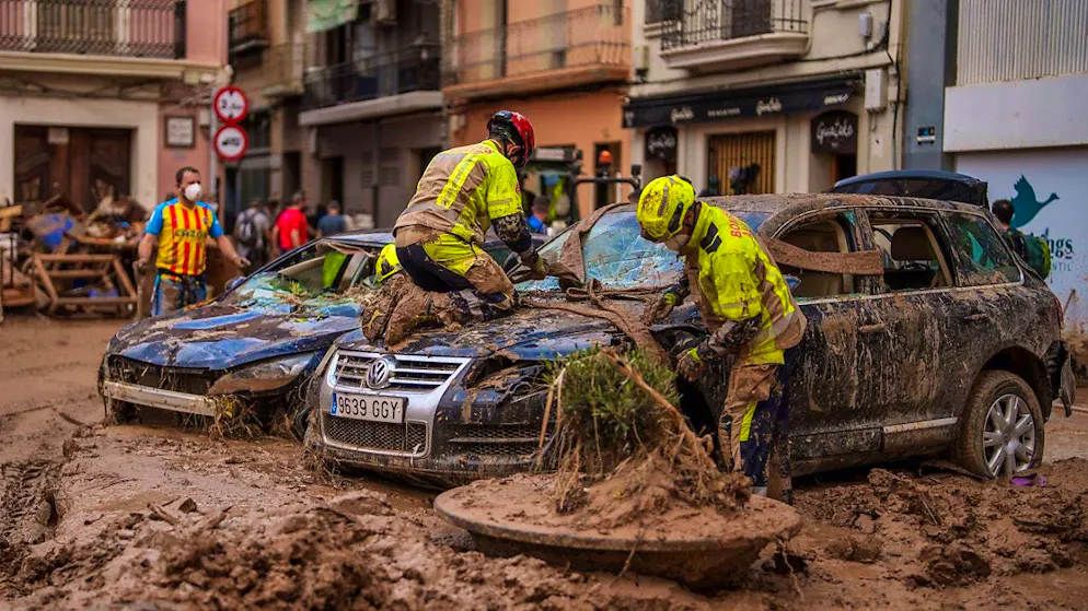 Firefighters remove a car from the mud in an area affected by floods in Algemesi, Spain. Photo: Manu Fernandez/AP/dpa