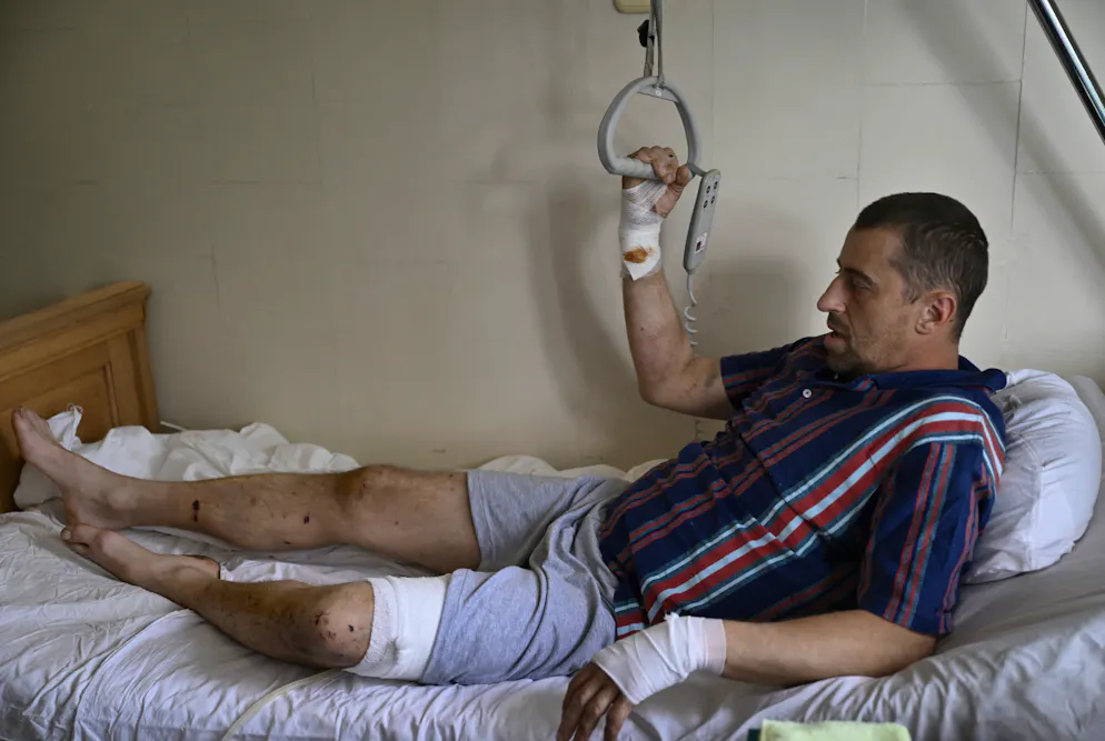 Anton Sushko, soldat ukrainien blessé, est allongé sur son lit à l'hôpital Mechnikov de Dnipro, le 26 septembre 2024, lors de l'invasion de l'Ukraine par la Russie. - Les combats directs et les frappes aériennes ont provoqué une augmentation du nombre de patients souffrant de blessures traumatiques, qui ont submergé les hôpitaux en sous-effectif. L'hôpital Mechnikov de Dnipro a vu sa charge de travail décupler, a déclaré le chirurgien en chef Sergiy Kosulnykov. (Photo Genya SAVILOV / AFP)