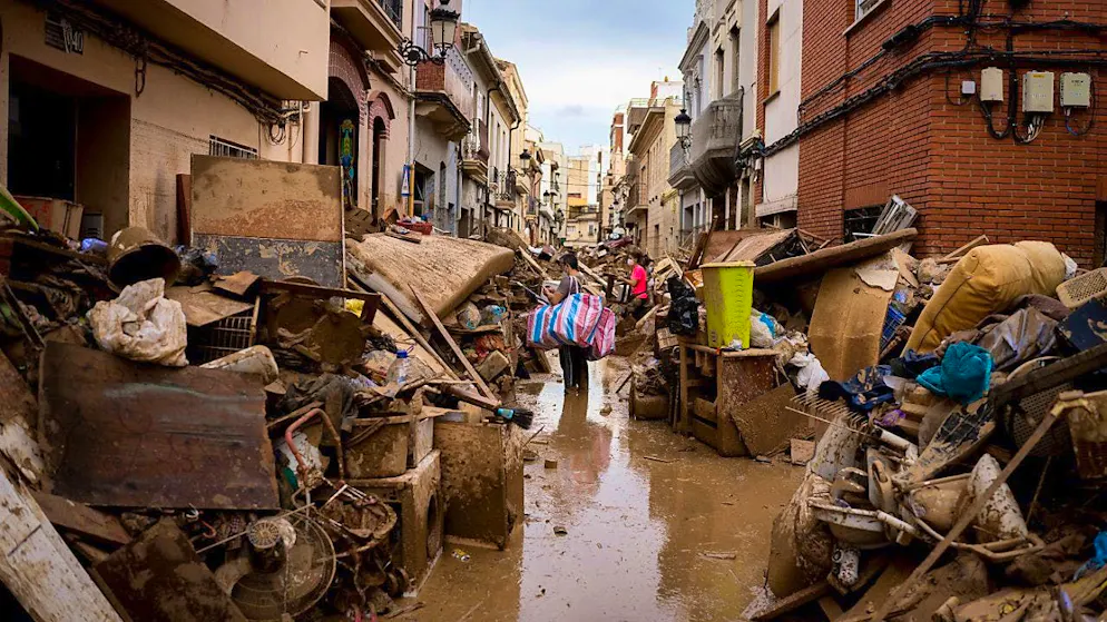 dpatopbilder - Locals and volunteers through mud-filled streets of Paiporta, past bulky garbage. These floods with many deaths are considered the worst disaster in the history of Spain and one of the worst in the history of Europe. Photo: Davide Bonaldo/SOPA Images via ZUMA Press Wire/dpa