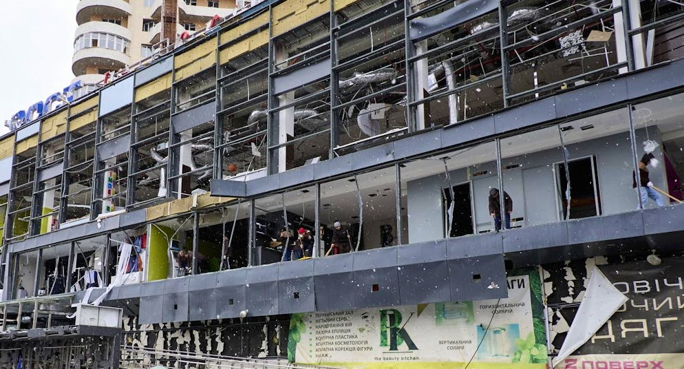 Delle persone puliscono i detriti sul luogo di un attacco con una bomba volante russa su una zona residenziale a Kharkiv in Ucraina.