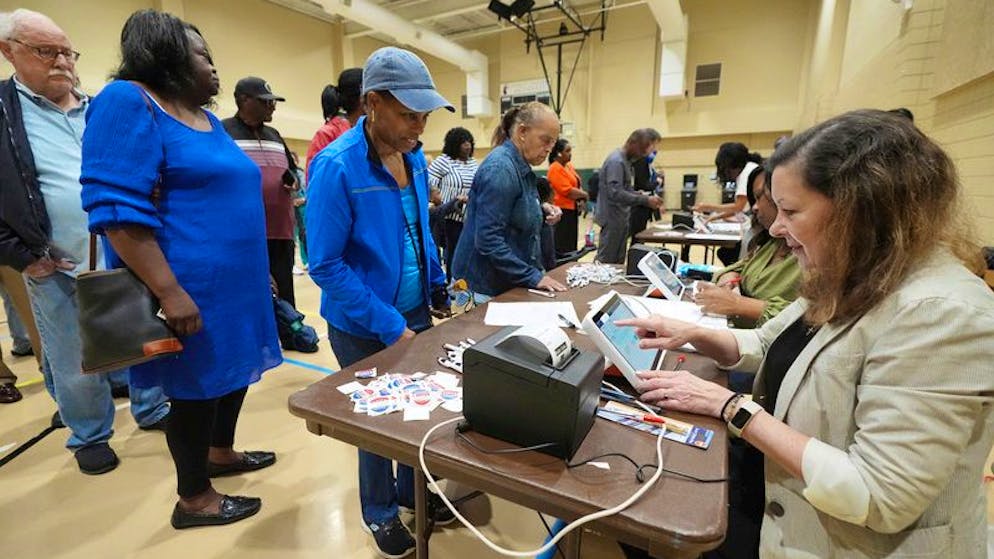 Trump oder Harris? Wahltag in den USA. Eine Mitarbeiterin des Wahllokals im Norden von Jackson, Florida, registriert am frühen Morgen elektronisch einen Wähler.