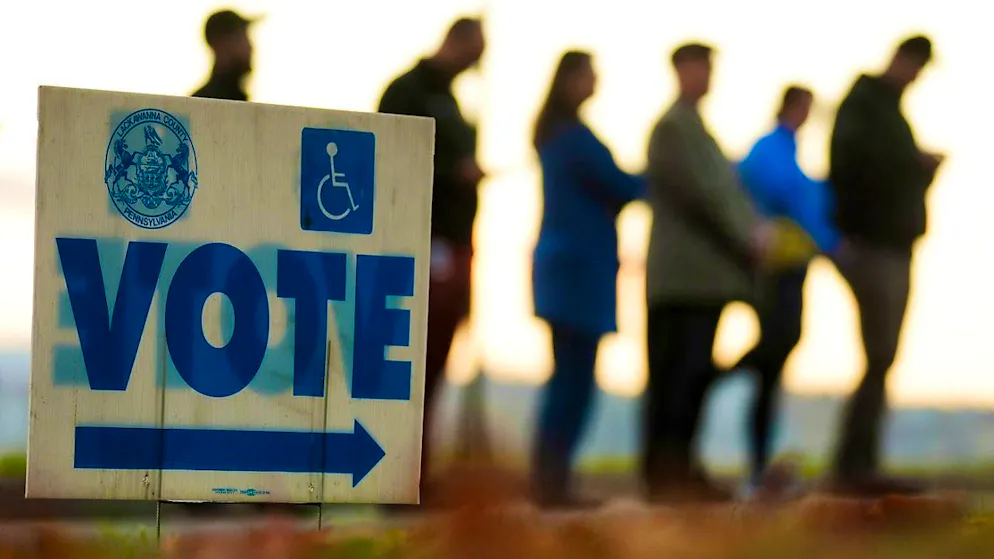Voters wait in line to cast their votes. Photo: Matt Rourke/AP/dpa