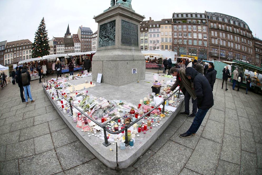 Des personnes autour de bougies, lettres et fleurs sur une place proche du marché de Noël, à Strasbourg, en France, le 14 décembre 2018, où l'attaque terroriste a eu lieu.
