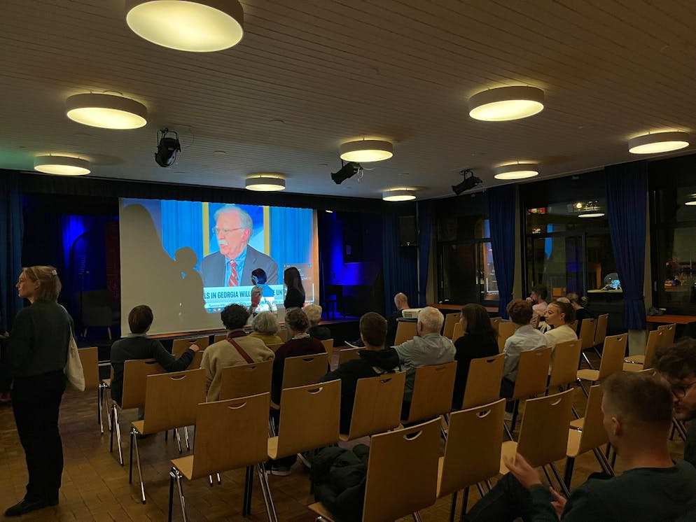 US-Wahlen Zürich. In einem weiteren Saal befindet sich ein weiterer Bildschirm. Auch hier schauen die Leute gespannt auf den Bildschirm.