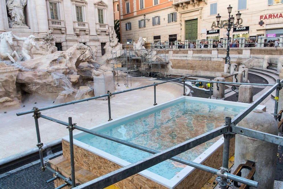 Alla Fontana di Trevi, circondata da una rete a causa dell'inizio dei lavori di manutenzione, è stata installata una vasca rettangolare per permettere ai turisti il tradizionale lancio delle monete.