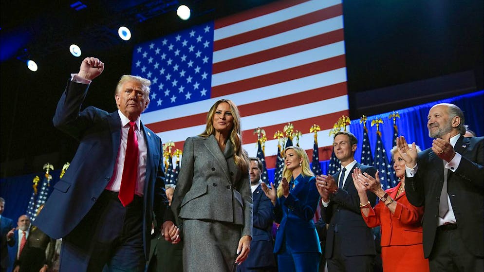 Der republikanische Präsidentschaftskandidat und frühere US-Präsidentschaftskandidat Donald Trump (l-r) gestikuliert neben der ehemaligen First Lady Melania Trump bei einer Wahlparty zu den US-Wahlen im Palm Beach Convention Center. Foto: Evan Vucci/AP/dpa
