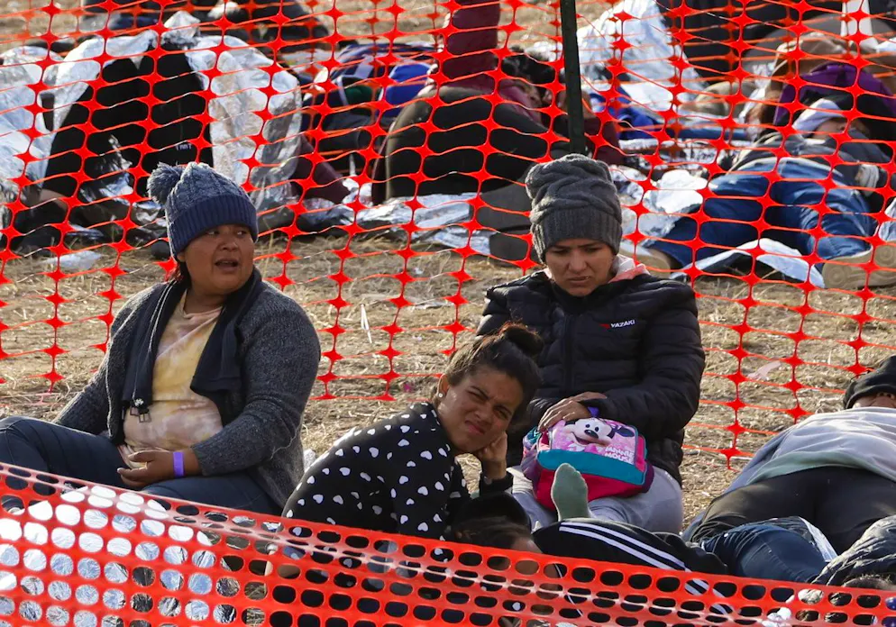 Des migrants attendent pour monter dans un bus à Shelby Park à Eagle Pass, Texas, États-Unis, en 20 décembre 2023.