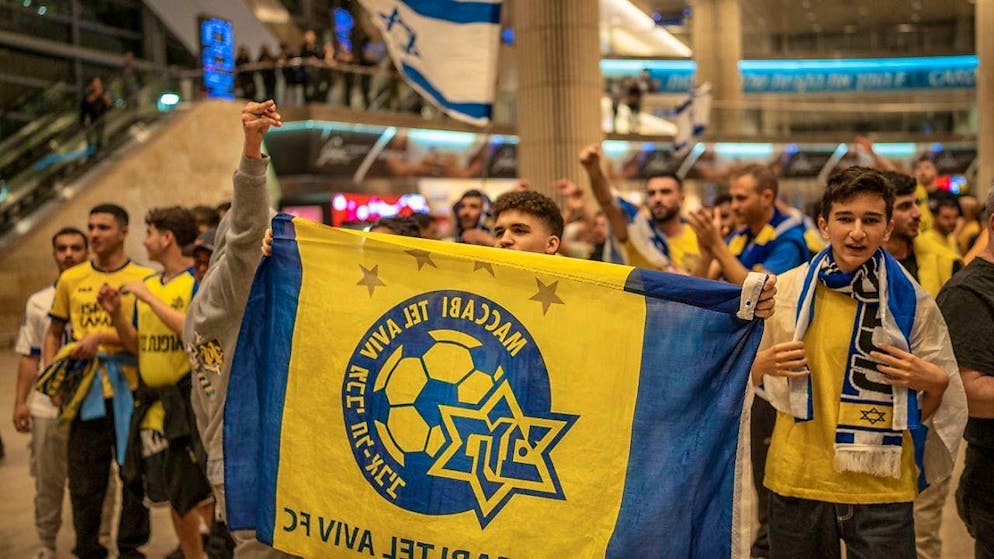 Fans of Maccabi Tel Aviv cheer as they arrive at Ben Gurion Airport on a plane from Amsterdam. Photo: Ilia Yefimovich/dpa