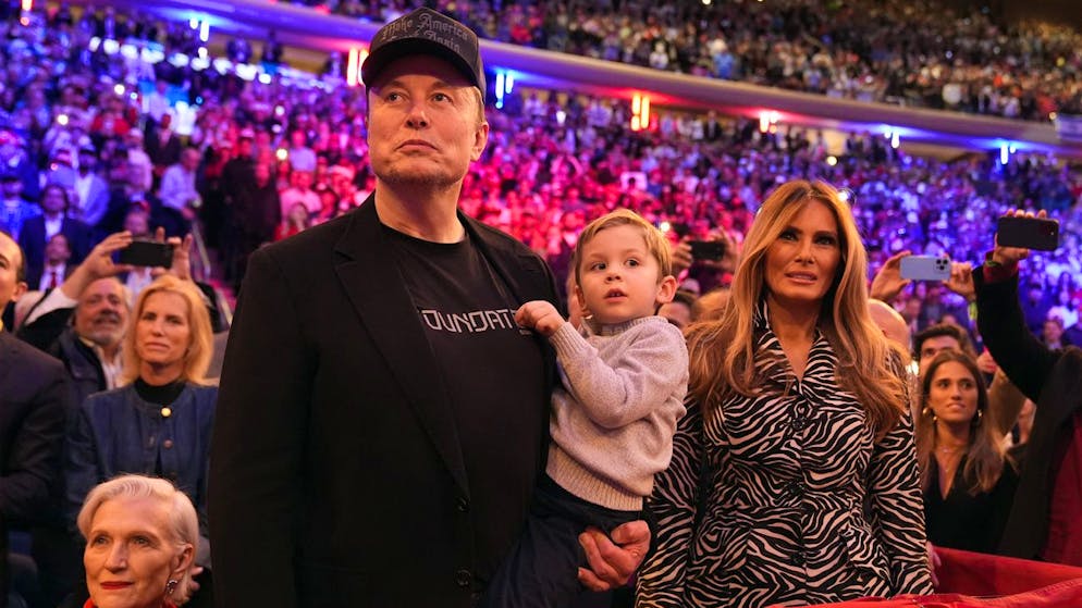 Elon Musk – mit einem seiner elf Kinder auf dem Arm – und Melania Trump (r.) hören Donald Trump bei einem Wahlauftritt in New York zu. (27. Oktober 2024)