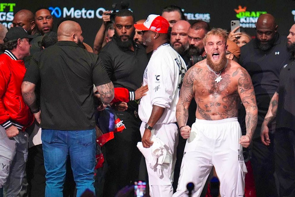 The pictures of the boxing match between Mike Tyson and Jake Paul. While Tyson is being held back, Paul (white trousers) shouts something in the direction of the photographers.