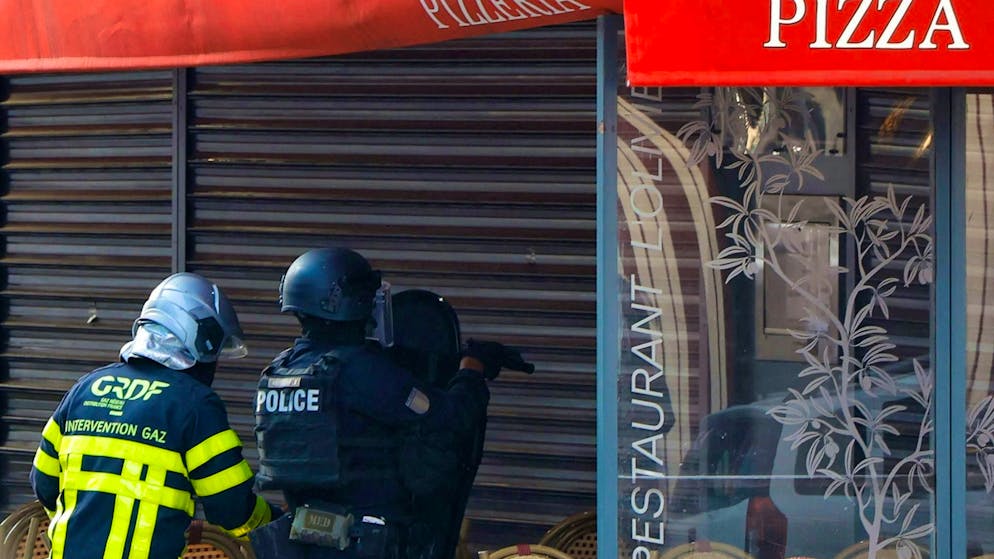 Police officers stand outside the restaurant in Issy-les-Moulineaux.