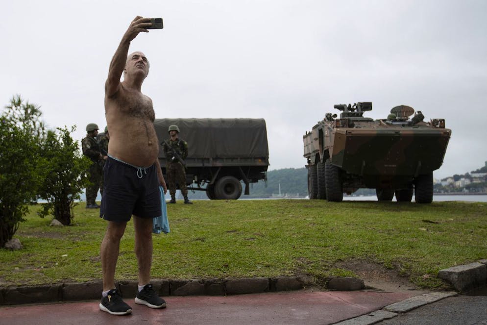 Un homme prend un selfie alors que des soldats patrouillent près du lieu du prochain sommet du G20, dans le quartier de Flamengo à Rio de Janeiro, vendredi 15 novembre 2024. (AP Photo/Bruna Prado)