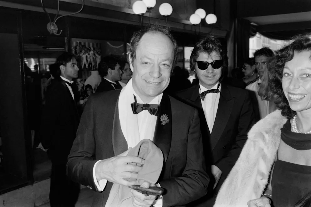 (FILES) Les chanteurs français Charles Dumont (C) et Daniel Guichard arrivent au cabaret du Moulin Rouge pour le spectacle de Dean Martin à Paris le 3 juillet 1984. - Le musicien Charles Dumont, compositeur du légendaire « Je ne regrette rien » d'Edith Piaf, est décédé dans la nuit du 17 au 18 novembre 2024 à Paris à l'âge de 95 ans, a annoncé sa compagne Florence à l'AFP. Cet auteur-compositeur-interprète, qui avait également collaboré avec Barbra Streisand, est décédé des suites d'une longue maladie à son domicile. (Photo Philippe WOJAZER / AFP)