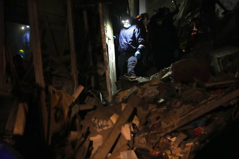 Un soccorritore cerca le vittime all'interno di un edificio distrutto colpito da un attacco aereo israeliano nel centro di Beirut.