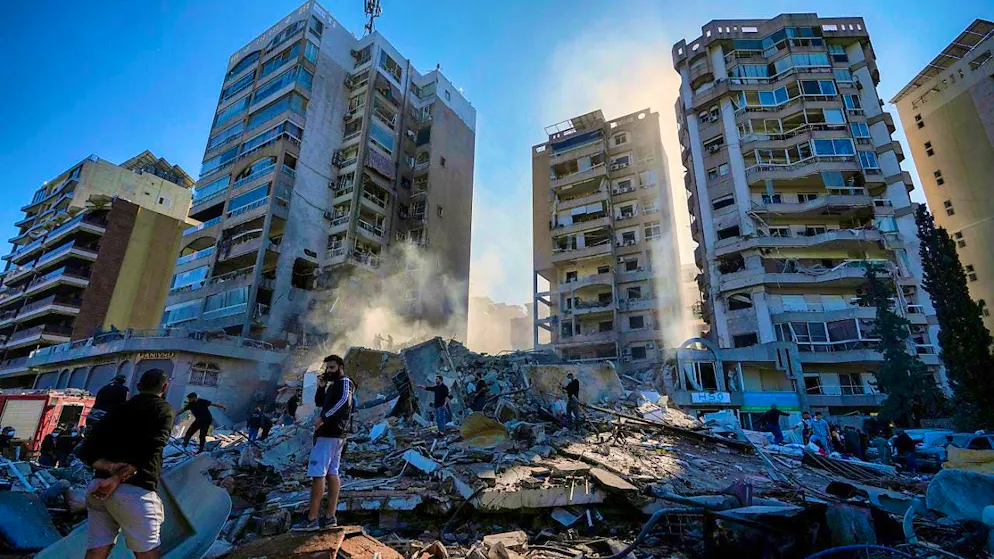 Residents search a collapsed building in the Tajuna neighborhood after an Israeli airstrike. Photo: Hassan Ammar/AP
