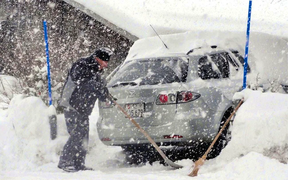 Snow shoveling in Lain GR on Saturday, December 31, 2011. (KEYSTONE/Walter Bieri)
