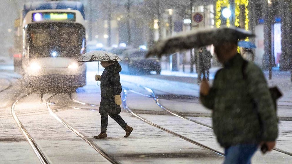 The first snow paralyzed traffic in many places - Gallery. With umbrellas in the snow: passers-by in Zurich on Thursday.