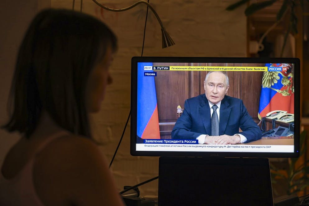 Una persona segue il discorso televisivo di Putin a Mosca. 