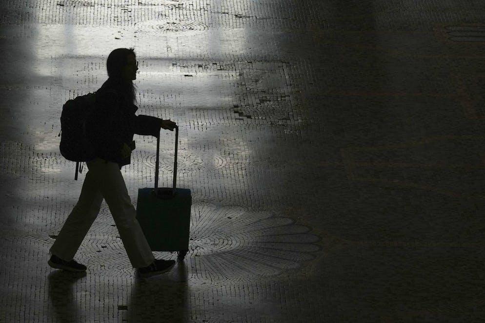 A woman walks at the train station during a nationwide transport strike, in Milan, Italy, Friday, Nov. 8, 2024. (AP Photo/Antonio Calanni)