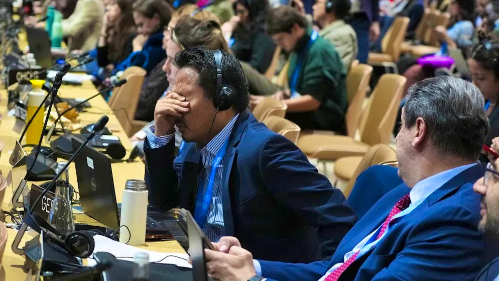 A participant at COP29 in Baku reacts to what is happening at the closing plenary session.